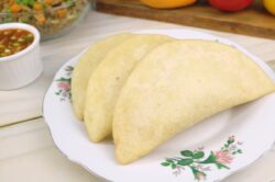 Empanadas de morocho doradas en un plato, con ají al lado