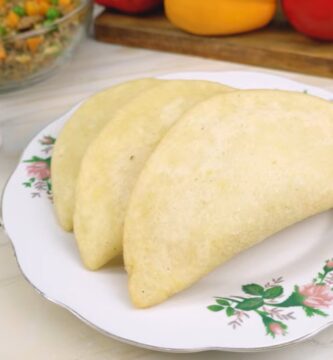Empanadas de morocho doradas en un plato, con ají al lado