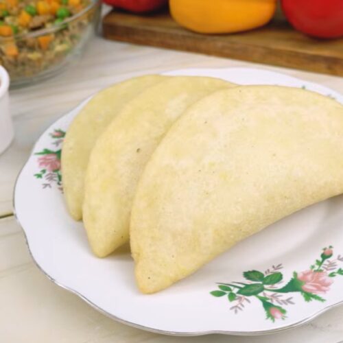 Empanadas de morocho doradas en un plato, con ají al lado