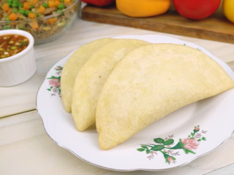 Empanadas de morocho doradas en un plato, con ají al lado